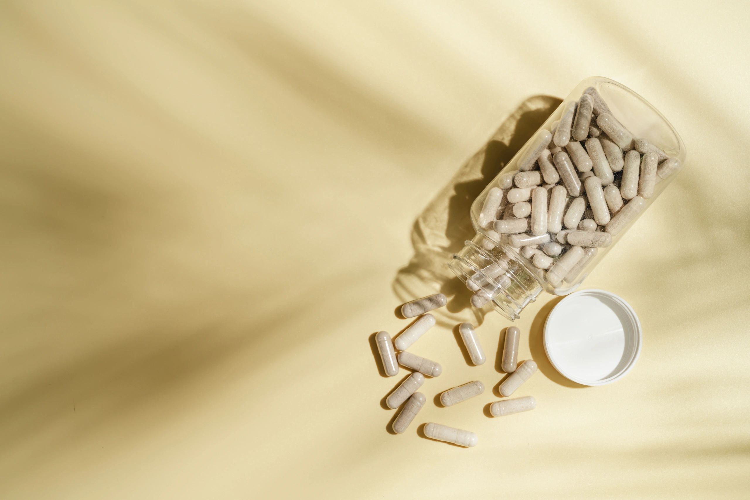 Supplement capsules and powder arranged in a clean flat lay
